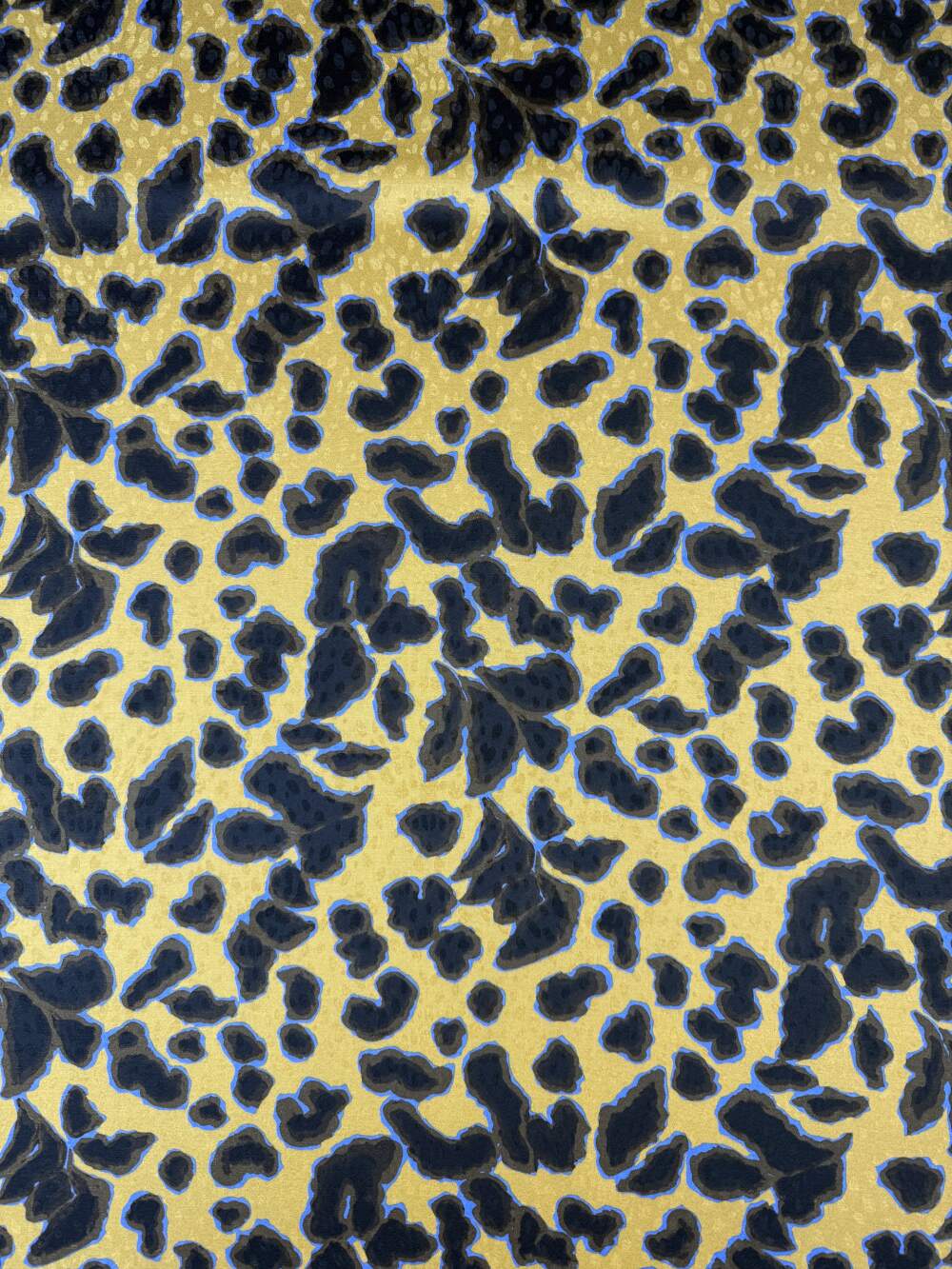 Tessuto jacquard animalier con base dorata e dettagli in rilievo.