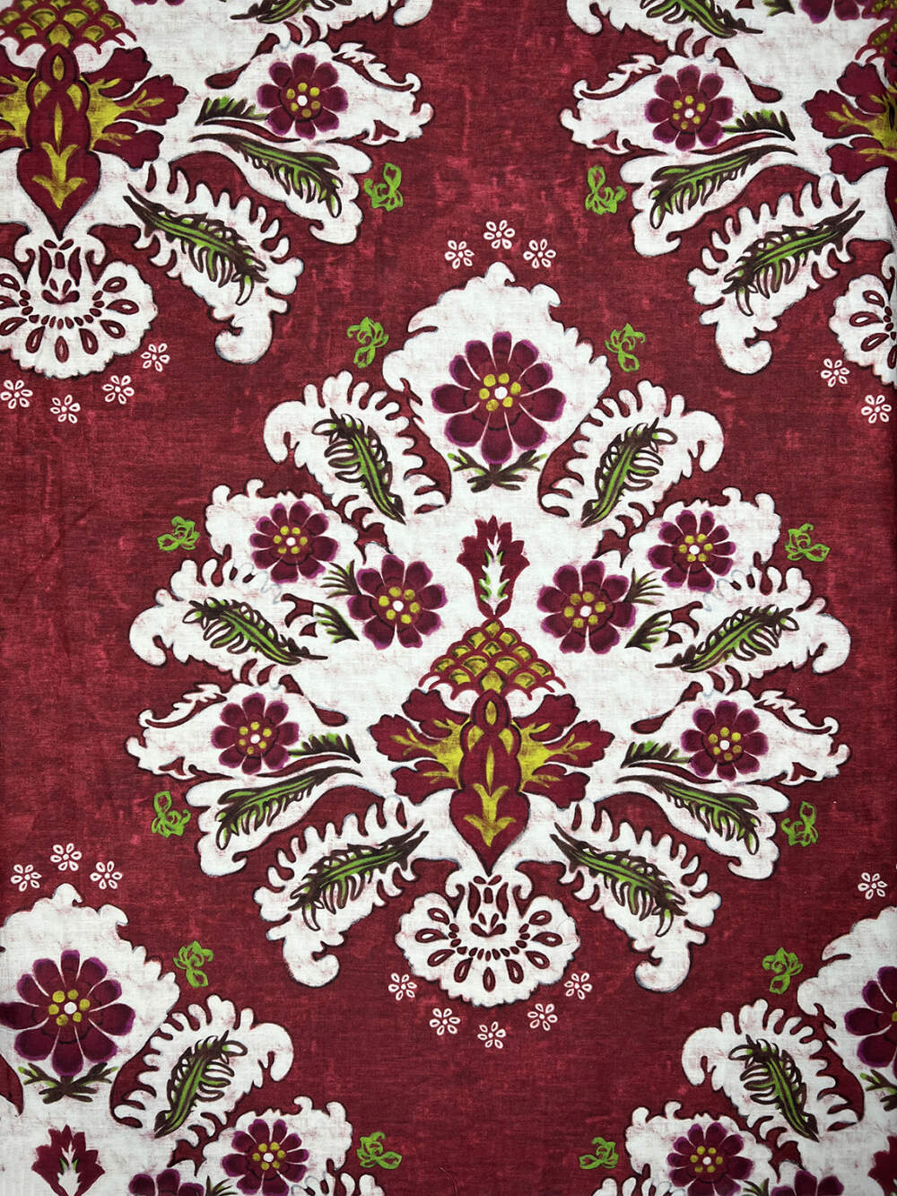 Tela di cotone e lino con motivi floreali color rosso amaranto, giallo, e verde